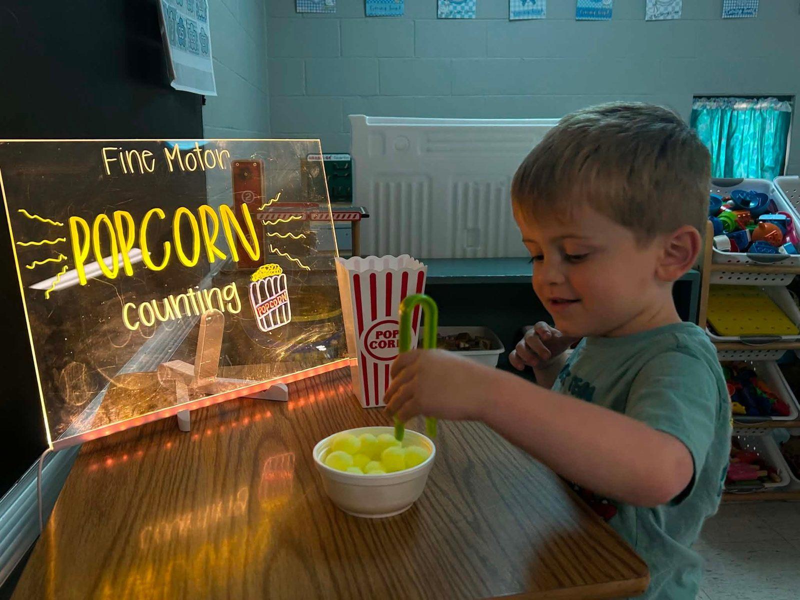 Preschooler practicing fine motor skills with a popcorn counting activity