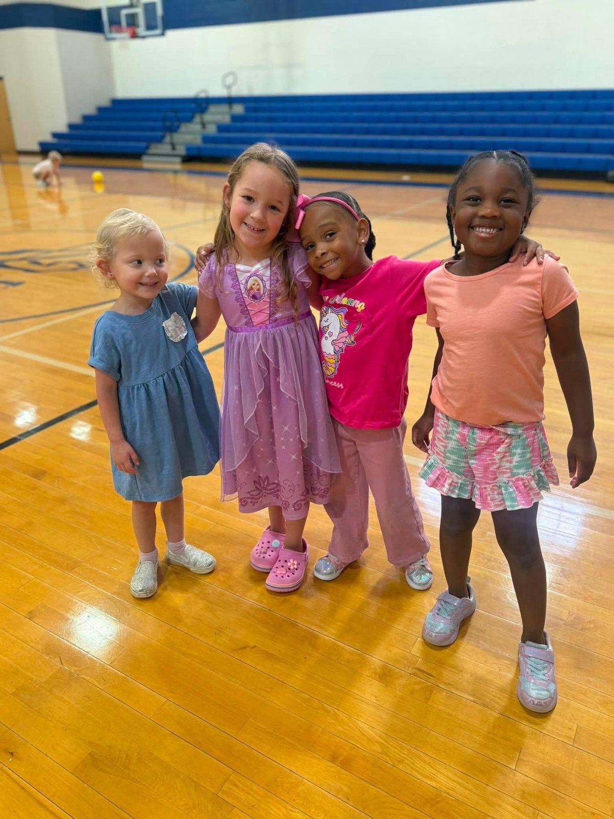 Four friends posing together in the gym