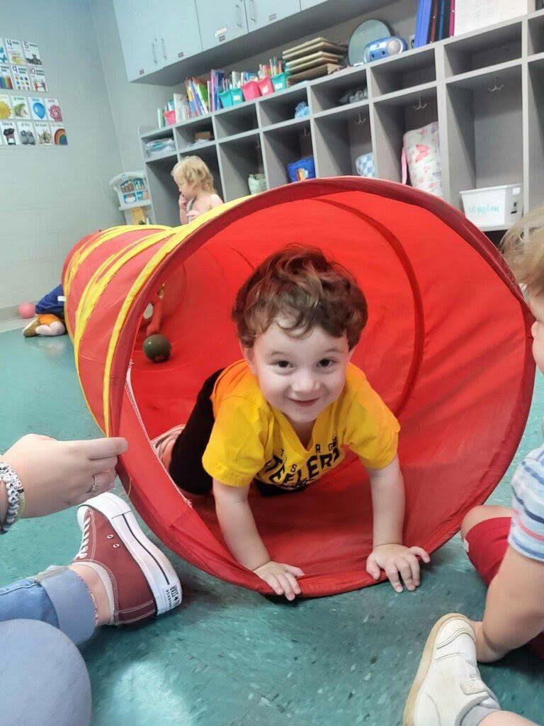 Toddler crawling through a play tunnel